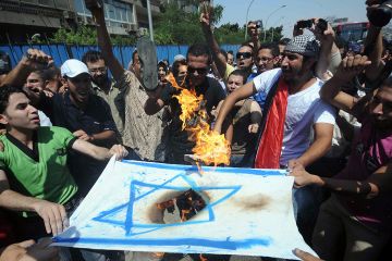 Protesters burning Israeli flag
