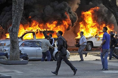 Les voitures de la police scientifique vénézuélienne incendiées lors de manifestations anti-gouvernement, le 12 février 2014, à Caracas.