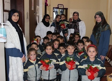 أطفال مدرسة المهدي(ع) يقدمون الأزهار لممرضات مركز الهيئة الصحية