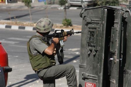 Zionist soldier fires at Palestinians in the Occupied Territories. (Archive)