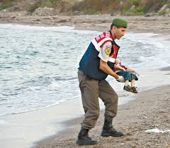 Turkish policeman carrying tthe body of Syrian refugee todddler who drowned on Turkish beach Aylan Kurdi