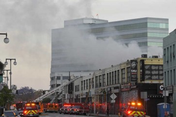 Los Angeles Fire Department firefighters work the scene of a structure fire that injured multiple firefighters, according to a fire department spokesman, Saturday, May 16, 2020, in Los Angeles. (AP Photo/Mark J. Terrill)