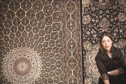 Une iranienne dans une exposition de tapis faits à la main à Téhéran